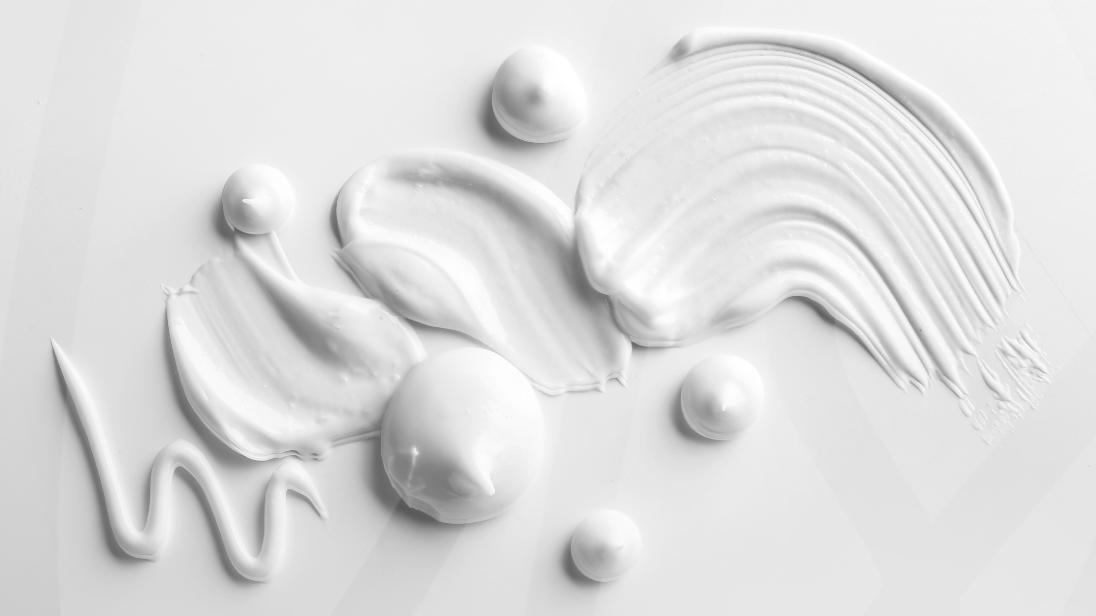 Different white cream textures and shapes on a white monochrome background cover of the US Lab Technology's article for oily skin